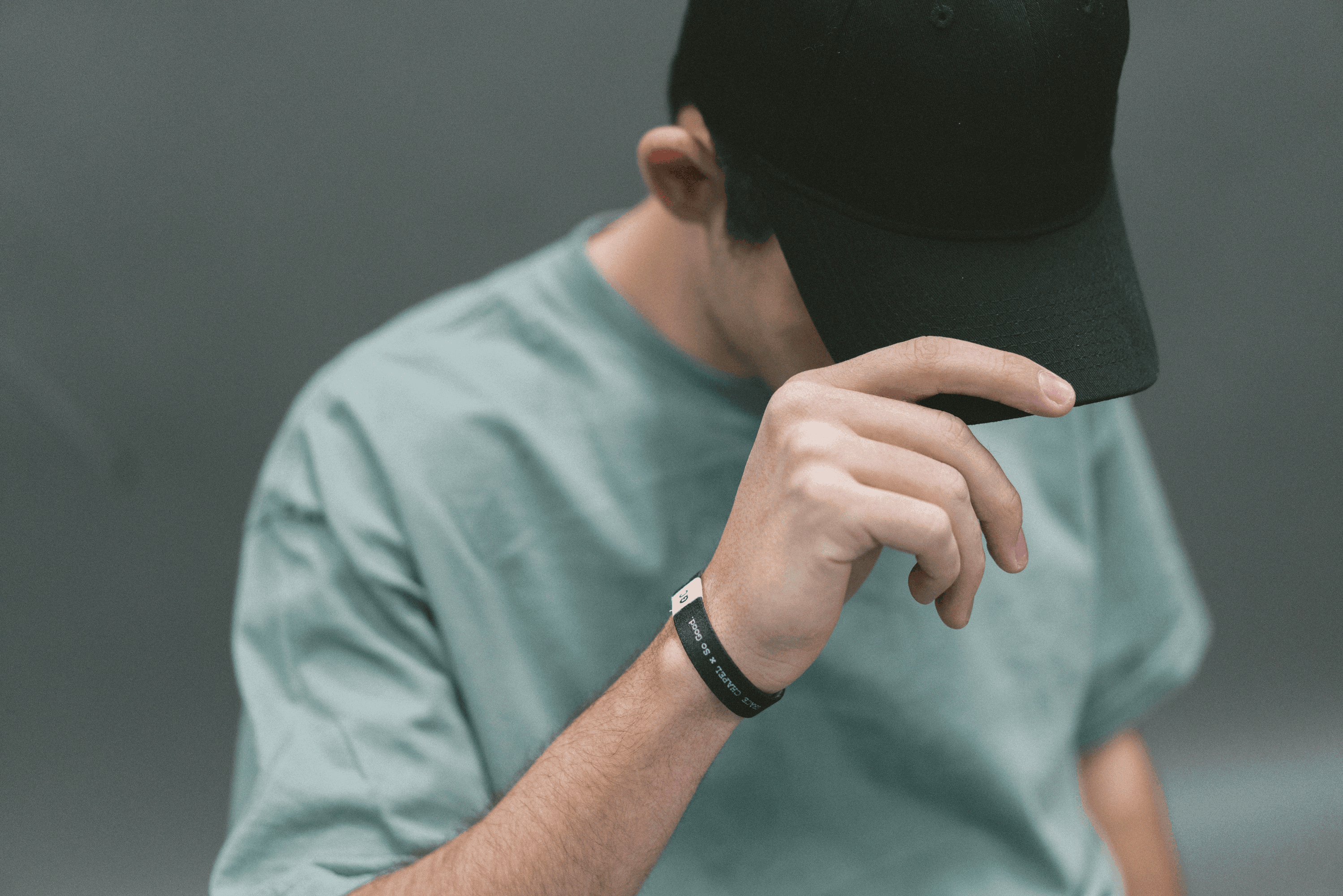 boy holding a cap in his head